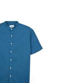 Chemise à manches courtes avec col, en bleu sarcelle profond. Fabriquée en tissu léger, elle présente une patte de boutonnage sur le devant et un design épuré et simple.