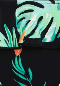 O tecido do fato de banho apresenta um fundo preto com grandes folhas tropicais verdes e detalhes em laranja. Textura suave com costura precisa.