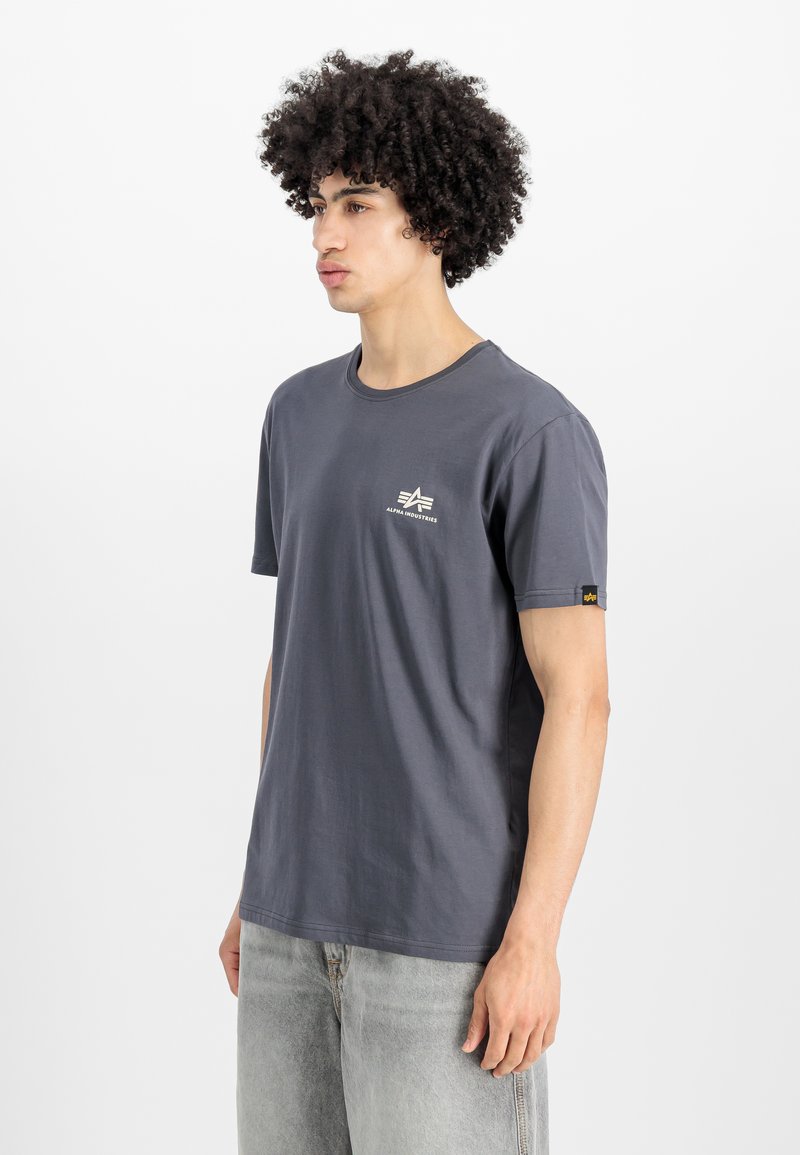 Hall hõbedane puuvillane T-särk lühikeste varrukatega, ümar kaelus ja väike logo vasakul rinnal. Kandmine heledate hallide teksadega. Pehme tekstuur.