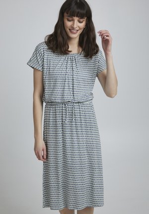Kurzarmkleid mit lässiger Passform, das ein navy-weißes geometrisches Muster aufweist, eine taillierte Taille hat und mit einem Bindeband am Ausschnitt gestaltet ist.
