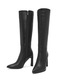 Botas de cuero negras hasta la rodilla con punta afilada y tacón alto de aguja. Cierre de cremallera lateral y detalles texturizados en el panel de la cremallera.