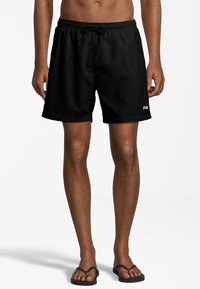 Pantaloni da bagno neri realizzati in materiale leggero, con un cinturino elastico dotato di cordino e un piccolo logo bianco sull'orlo sinistro.
