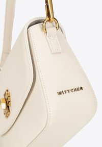 Sac en cuir crème avec une forme structurée, quincaillerie en ton doré et logo "WITTCHEN" embossé. Doté d'une seule bandoulière.