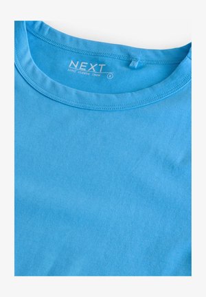 Camiseta de manga larga tipo crew en algodón azul claro sólido. Presenta un cuello redondo y costuras simples. La etiqueta dice "NEXT", talla S.