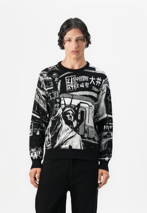 Strickpullover mit einem schwarz-weißen Grafikdesign, das die Freiheitsstatue und Stadtszene-Elemente zeigt, mit gerippten Bündchen und Saum.