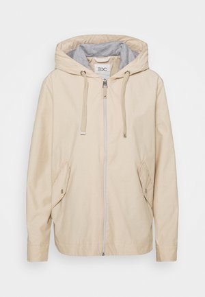 Beige hættetrøje med frontlynlås, snor i hætten og to knaplukning lommer med klap, foret med lysegråt stof.