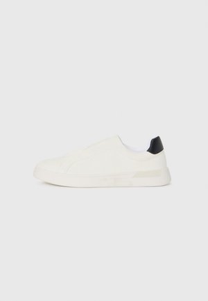 Białe sneakersy z gładką kanwą, elastycznym wzornictwem i czarnym akcentem na pięcie. Posiadają fakturowaną gumową podeszwę.