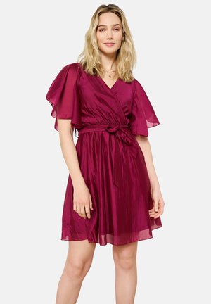 Kurzes, fließendes Wickelkleid in tiefem Magenta, mit flatternden Ärmeln, einem taillierten Knoten und einem weichen, strukturierten Stoff.