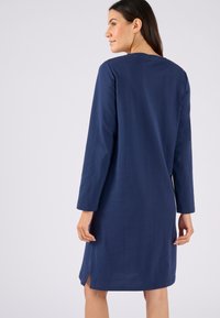 Abito lungo blu navy a maniche lunghe con scollatura rotonda, fessure laterali e texture liscia, progettato per una vestibilità comoda.