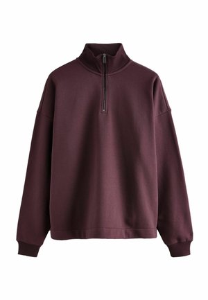 Burgundowa bluza z wysokim kołnierzem, półzamkiem i ściągaczami na rękawach. Miękka tekstura i luźny krój. Bez widocznych wzorów ani grafik.