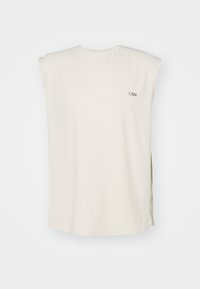 Top senza maniche color crema con scollatura a V, caratterizzato da leggere aperture laterali e un piccolo logo nero sul davanti. Tessuto liscio e leggero.