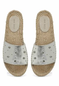 Srebrne sandale za klizanje s metalik završnom obradom, ukrašene suptilnim rhinestones; potplat od jute užeta; udoban ravni dizajn.