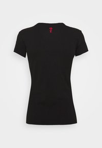 Camiseta negra de manga corta de algodón, con cuello redondo y un pequeño logo rojo en la parte posterior cerca del escote.