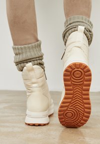 Botine cu glezna din materiale cu aspect crem, căptușite, cu un finisaj texturat, dotate cu o talpă din cauciuc portocalie și detaliu de manșetă din tricot.