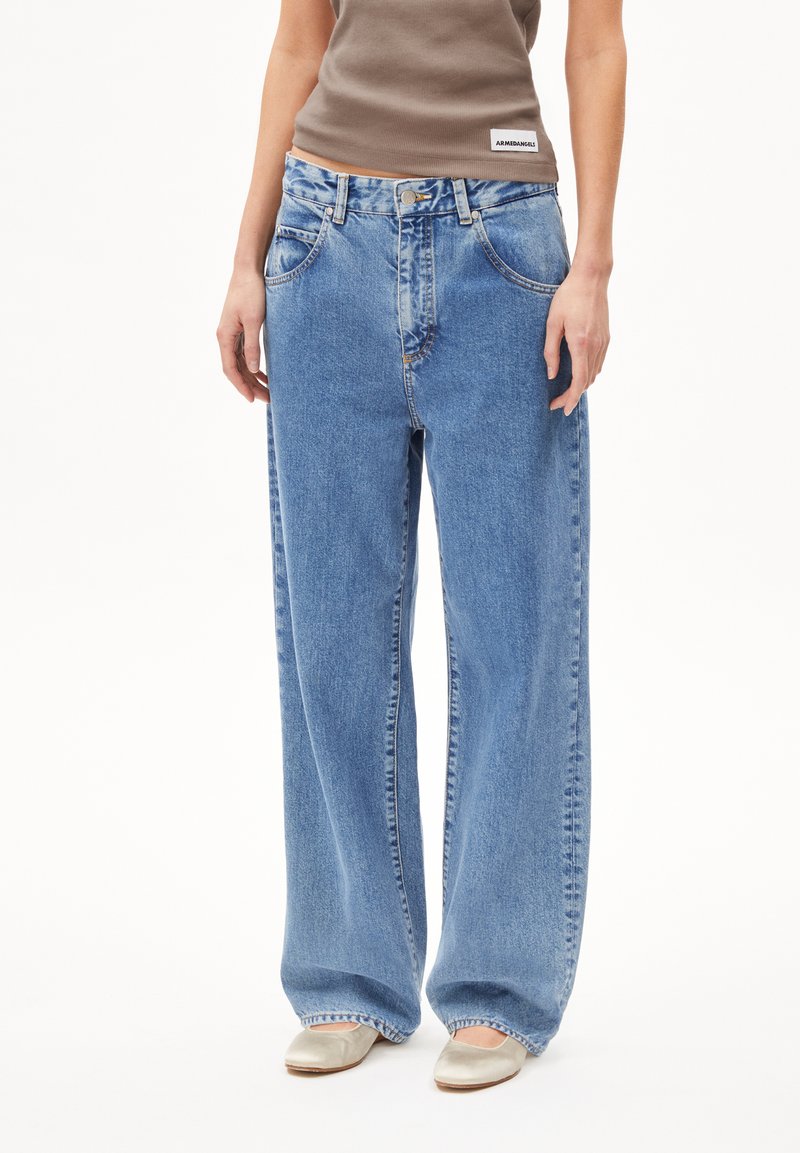Wide-leg blue denim jeans with a light wash, featuring a button closure, five pockets, and visible stitching. Made from durable cotton fabric.