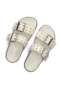 Beige sandalen met twee brede banden, zilveren studs en gespen. Gladde synthetische bovenkant, platte zool en gevoerde binnenzool. Logo gedrukt aan de binnenkant.
