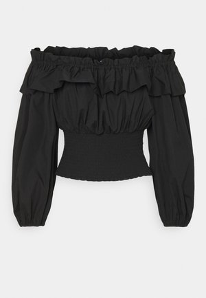 Haut noir épaules dénudées avec détails à volants et manches bouffantes longues, présentant une taille smockée et une texture de tissu lisse.