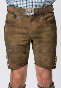 Pantaloni corti in pelle marrone con una finitura testurizzata, caratterizzati da ricami decorativi e dettagli con bottoni sui lati, abbinati a una fibbia in argento.