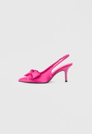 Escarpin slingback rose vif à talon haut avec bout pointu et grand nœud décoratif sur le dessus, sur fond clair uni.