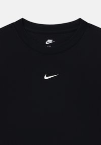 T-shirt noir Nike avec un col rond, comportant un petit logo Nike blanc sur la poitrine. Tissu lisse, manches courtes, design basique.