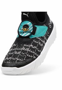 Sneaker nera con motivo di gatti, dettagli in teal e una toppa circolare con un personaggio. Realizzata in tessuto con una suola in gomma bianca.