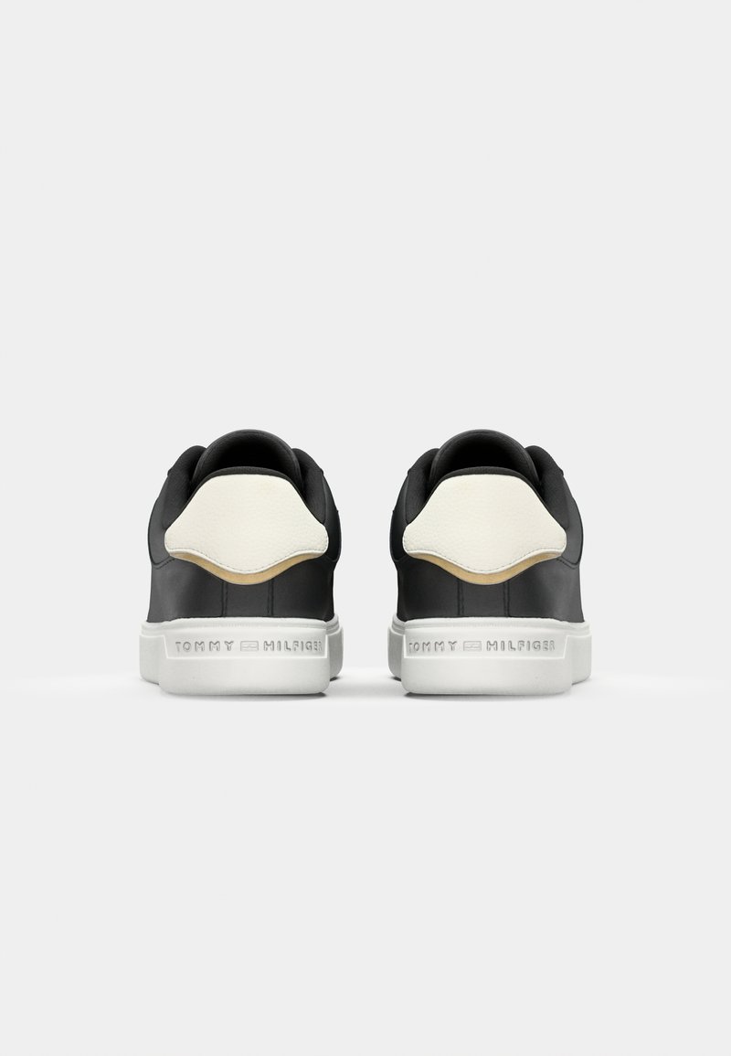 Zapatillas en blanco y negro con parte superior de cuero liso, forma redondeada, suela de goma blanca y un discreto logo en el talón.