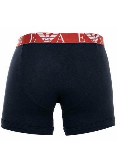 Marineblaue Boxershorts mit einem roten elastischen Bund, der weißen Schriftzug und Grafikdesign aufweist, aus weichem Baumwollmaterial hergestellt.