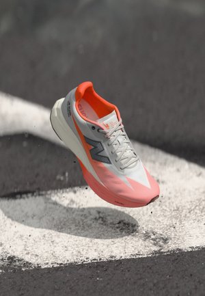 Chaussure de course au design léger, tige grise et rose, semelle intermédiaire blanche et surface texturée. Dotée d'un logo et de lacets pour un maintien sécurisé.
