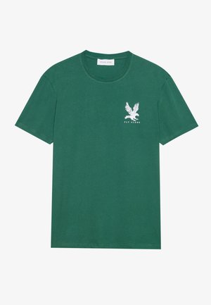 Grünes Baumwoll-T-Shirt mit Rundhalsausschnitt, kurzen Ärmeln und einem weißen Adler-Design mit dem Text "FLY ALONE" auf der linken Brust.
