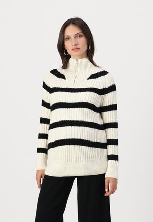Black and cream striped knitted sweater with a high collar and half-zip closure. Ribbed texture on sleeves and bottom hem.