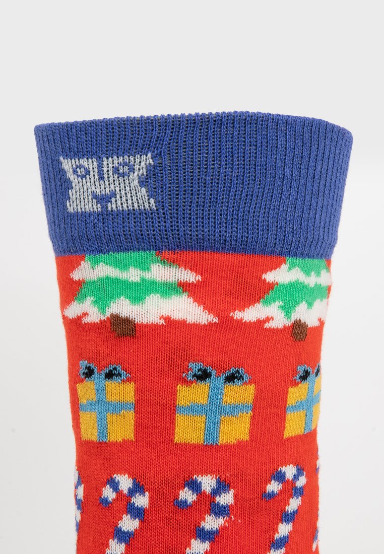 Rote Weihnachtsstrumpf mit grünen Bäumen, gelben Geschenken und blauen Zuckerstangen. Gerippter blauer Bund. Aus weichem Strickmaterial hergestellt.