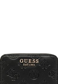 Portafoglio in pelle nera con motivi in rilievo, logo in tonalità oro "GUESS EST. 1981" e chiusura con zip lungo il bordo superiore.