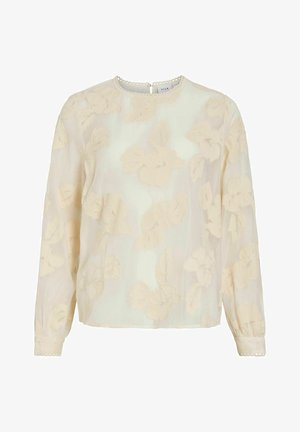Blouse Vila Floral en tissu crème transparent ; présente un motif floral en relief, des manches longues et un col rond festonné avec une fermeture au dos.