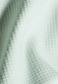 Licht mintgroene stof met een subtiele textuurpatroon en een gladde afwerking, die zachte draping en een lichte glans laat zien.