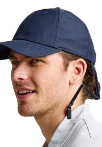 Cappello blu navy con una visiera ampia, tessuto testurizzato, dettagli cuciti e una cinghia regolabile sul retro. Design semplice, vestibilità informale.