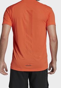 Orange atletisk skjorte med rund hals, korte ærmer og et perforeret vertikalt stribedesign på ryggen. Letvægtsstof.