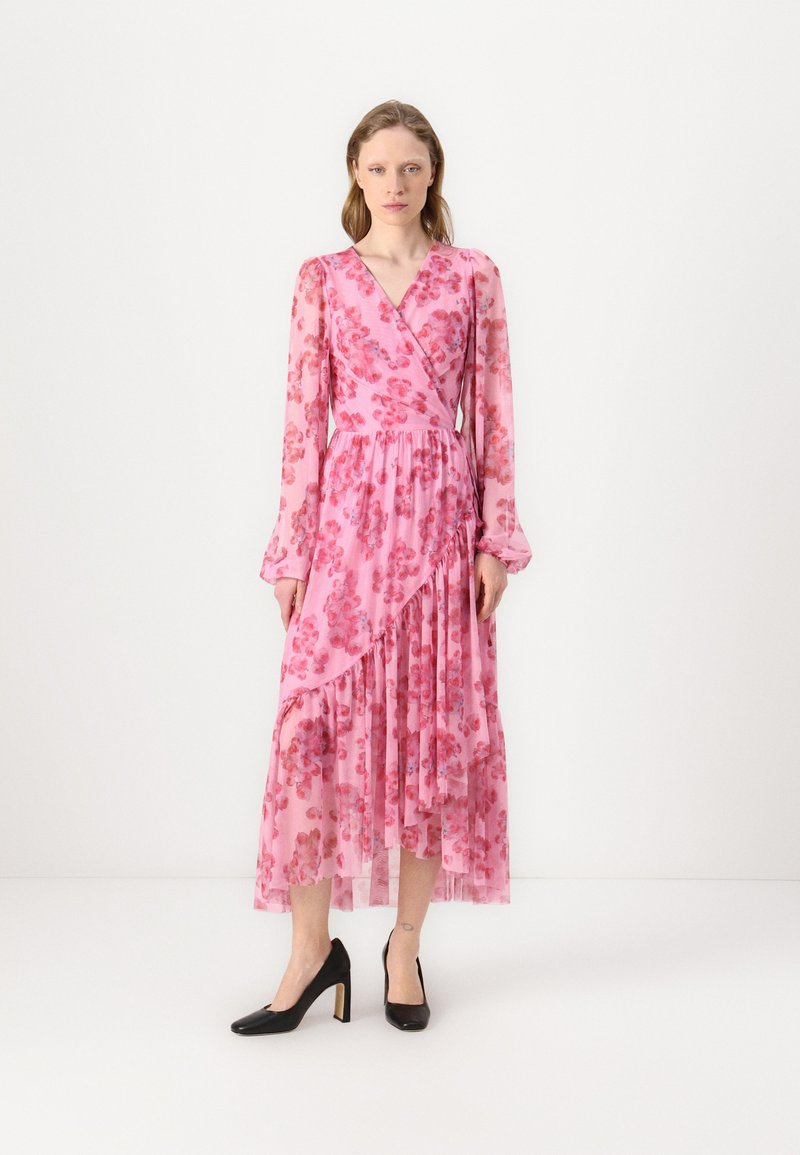 Robe maxi fleurie rose avec manches longues, design croisé et ourlet asymétrique. Fabriquée en tissu transparent avec des volants et une taille cintrée.