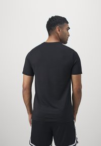 Schwarzes T-Shirt mit kurzen Ärmeln aus leichtem Stoff, verfügt über einen runden Halsausschnitt und eine glatte Textur. Keine sichtbaren Muster oder Details.