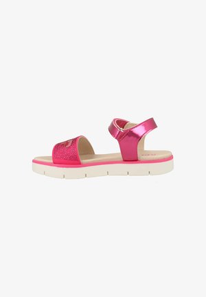 Roze sandalen met een glanzende lakafwerking, voorzien van een strap versierd met rhinestones en een witte rubberen zool. Inclusief verstelbare enkelband.