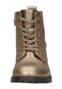 Metallisch bronzen enkellaars met een bovenwerk van gestructureerd leer, gouden oogjes en bruine veters. Platte zwarte rubberen zool met gripdetails.