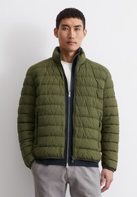 Olive green puffer jacket featuring a high collar, horizontal quilted pattern, and contrasting navy zipper. Two side pockets included.