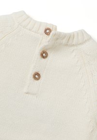 Cremfarbener Strickpullover mit geripptem Ausschnitt, drei Holzknöpfen und strukturierten Details am Körper und an den Ärmeln.