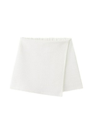 Carré de tissu rectangulaire blanc texturé, plié en deux, avec un motif tissé subtil et des bords festonnés.