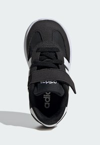 Černá sportovní bota s suchým zipem, šněrovacím designem, bílými akcenty a kulatou špičkou. Vyrobena z syntetického materiálu s texturovaným povrchem.