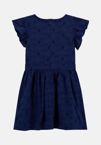 Navyblauwe jurk met korte gerimpelde mouwen, textiel met bloemborduursel en een geplooide rok. Achterzijde ritsluiting.