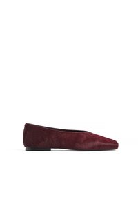Ballerine en rouge foncé, fabriquée en cuir avec poils. Présente une pointe aigüe et une semelle plate noire, mettant en valeur une texture lisse.