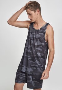 Svart og grå camouflagemønstrete tank top med løs passform og ribbestrikket halslinning, sammen med matchende shorts i et lignende mønster.