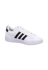 Weißer Sneaker mit niedrigem Schaft, schwarzen Streifen und Schnürsenkeln, mit dicker weißer Sohle und gepolstertem Kragen.