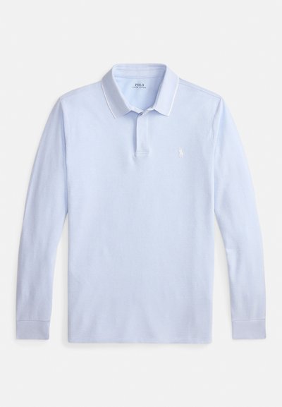 Gaiši zilas krāsas polo krekls ar garām piedurknēm, apkakli, pogu aizdari un mazu baltu izšūtu logotipu krūtīs.