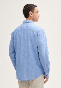 Lichtblauw overhemd met lange mouwen, gestructureerde stof, button-down kraag, achterkant met yoke-detail, afgeronde zoom, manchetten met één knoop.